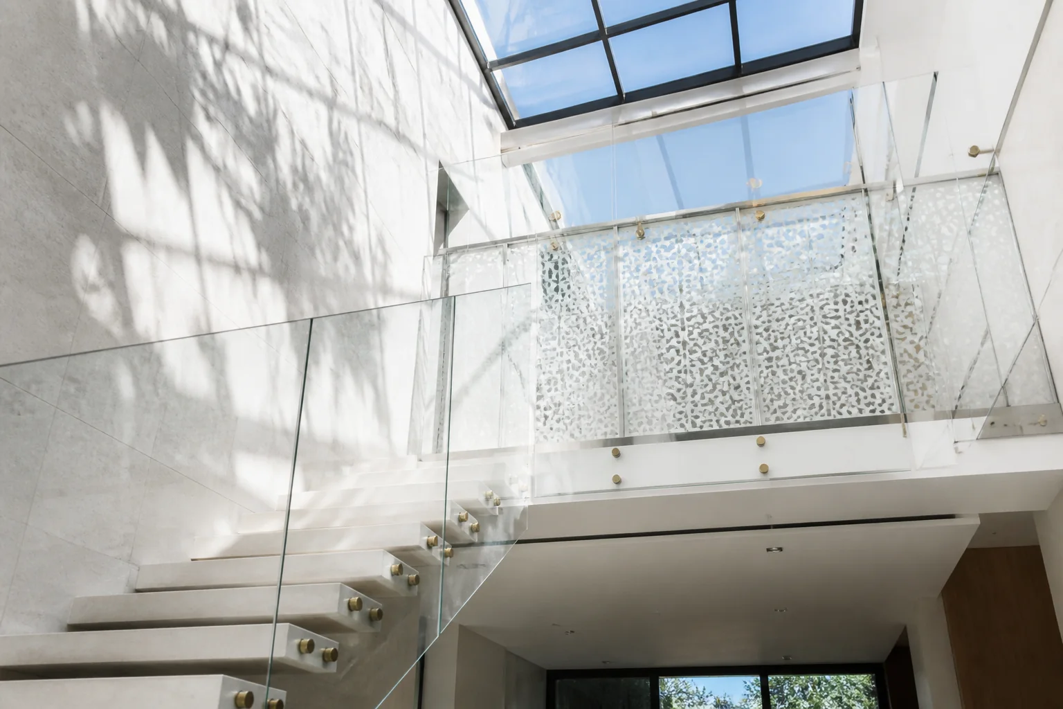 Frameless architectural tempered glass staircase balustrade with concealed floor-channel LED illumination